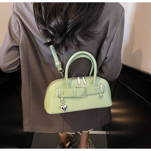 Détail du sac bowling vert menthe avec sangle décorative et pendentif coeur en argent