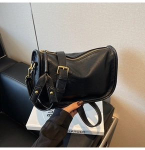 Detail of vintage black wrinkled leather bag with gold zipper and stylish side tassel