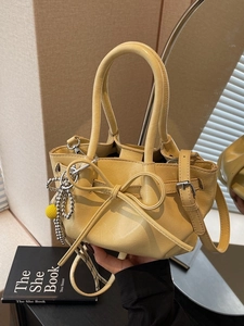 Modische blassgelbe Plissee-Beuteltasche mit Schleife und Metallketten-Detail