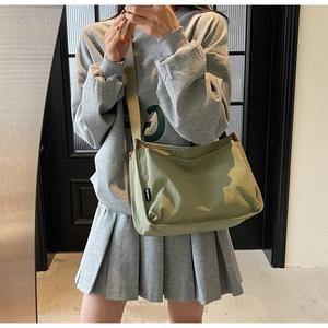 Detail view of the avocado green canvas tote bag showing the wide strap and small label