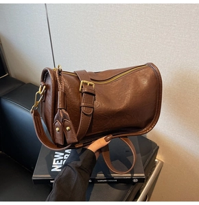 Close-up of vintage brown cylindrical bag with premium PU texture and gold hardware