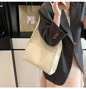 Close-up of minimalist cream white tote bag in premium lychee grain leather texture