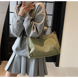 Detail of sage green canvas tote bag with adjustable strap and side woven label