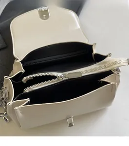 Detail of white leather shoulder bag featuring smooth silver zipper and interior lining