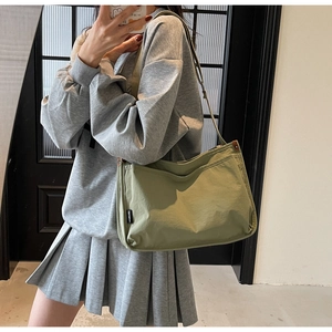 Detail of army green canvas tote bag with adjustable strap shown on model for daily use