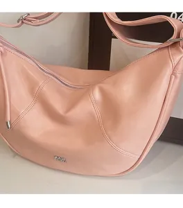 Gros plan d'un sac hobo en cuir souple rose montrant la texture et la fermeture éclair argentée