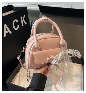 Detailed shot of pink glossy bowling bag with cute bow and pearl lace pendant charm
