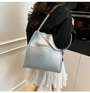 Sleek silver metallic tote bag with litchi texture shown on model side profile