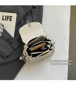 Macro shot of spacious beige flap bag interior with compartments and silver chain