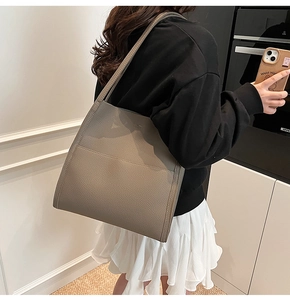 Grey lychee leather tote bag shown on model highlighting spacious size and daily commute style