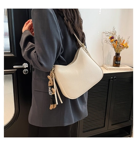 Off-white lychee grain leather hobo bag featuring a tassel and cute bunny charm accessory