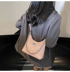 Detail of pink quilted hobo bag with silver chain strap and metal twist lock closure
