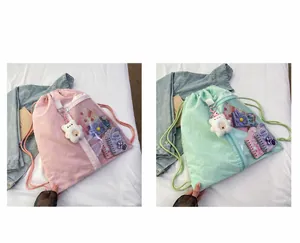 Pink and green drawstring backpacks with transparent PVC pockets and plush bear charms