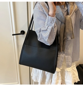 Close-up of black litchi pattern tote bag with large front pocket for office commute