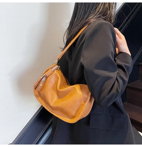 Close-up of brown vintage shoulder bag in soft leather with gold zipper details