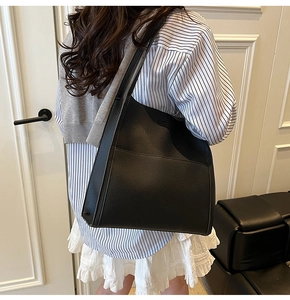 Close-up of black lychee grain leather texture and outer pocket on this tote bag