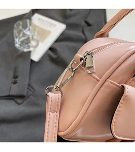Close-up of pink glossy bag featuring premium silver zipper and polished metal hardware