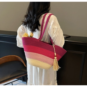Vue détaillée du sac tissé avec dégradés colorés et pompons élégants en perles de bois
