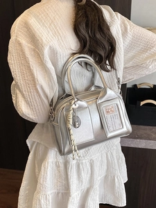 Silver boston handbag for women featuring metallic texture and a stylish cross-body strap