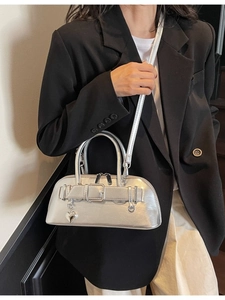 Sac bowling argenté avec pendentif cœur et bandoulière porté par un mannequin en noir
