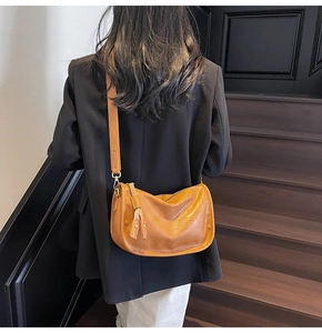 Detailed view of vintage brown crossbody bag with leather texture and side fringe accents