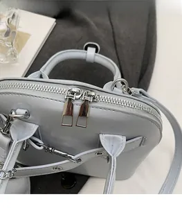 Macro detail of high-quality smooth metal zippers and silver hardware on a leather shell bag
