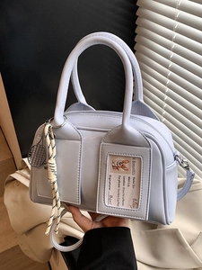 Light blue bowling style handbag with mini tennis racket charm and detachable strap