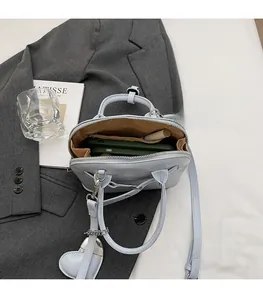 Internal view of light blue shell bag showing spacious storage for phone and makeup