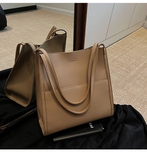 Detailed view of the tan lychee textured leather tote bag with a spacious front pocket
