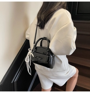 Mini black patent bowling bag with white lace pearl charm and delicate bow pocket detail
