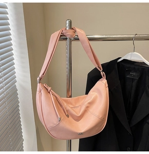 Détail du sac demi-lune rose avec logo JOUER en métal et cordon décoratif