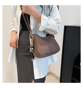 Détail du sac hobo en cuir marron avec dorures et accessoire de charme lapin mignon