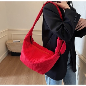 Close-up of red quilted nylon crescent bag with stylish knotted shoulder strap detail