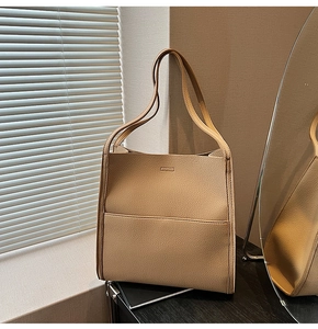 Detailed view of camel tote bag featuring premium pebbled leather texture and stitching