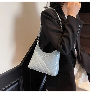 Close-up of quilted light blue patent leather bag with silver chain strap and metal lock