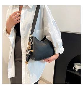 Détail du sac hobo en cuir grainé noir avec finitions dorées et pendentif lapin