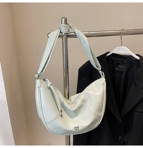 Vue détaillée du sac hobo vert menthe avec bandoulière nouée et logo en argent