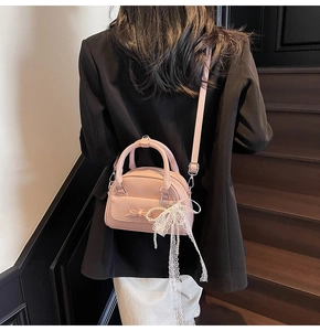 Pink bow handbag detail with white lace pearl charm and adjustable shoulder strap