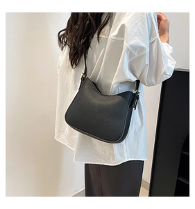 Detail of black pebbled leather hobo bag showing adjustable strap and golden metal buckle
