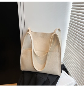 Macro shot of beige lychee texture leather tote bag featuring a front patch pocket
