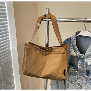 Detail of adjustable strap and durable khaki canvas tote bag in a lifestyle setting