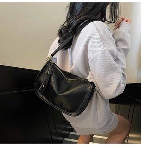 Detail view of black vintage baguette bag with pleated texture and gold metal hardware