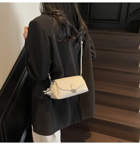 Detail of cream oil-wax leather shoulder bag with silver buckle and bunny charm