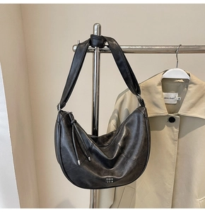 Détail du sac hobo noir avec anse nouée et logo métallique COIN RDM sur cuir vintage