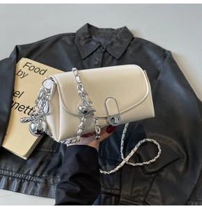 Detail of creamy white oil wax leather bag with chunky silver chain and metal ball charm