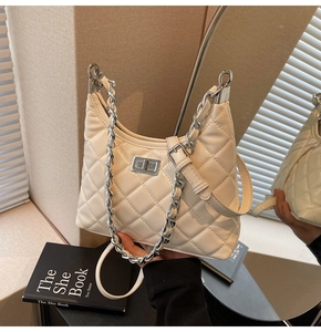 Close-up of cream quilted lattice bag featuring silver square twist lock and chain strap