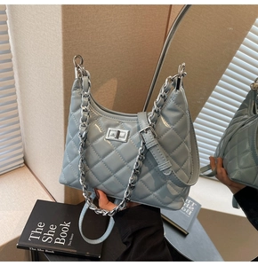 Detail of light blue quilted hobo bag featuring glossy finish and silver chain strap