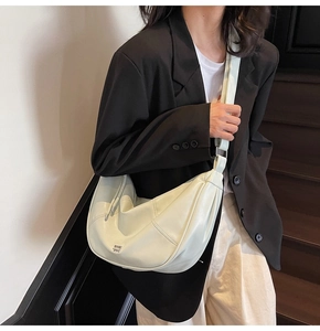 Détail du sac hobo vert menthe avec large bandoulière et logo gaufré sur mannequin