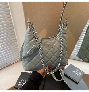 Detail of light blue quilted leather bag with silver chain and metal turn-lock