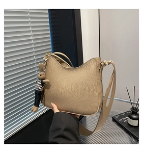 Détail du sac croissant kaki avec texture grainée et un pendentif lapin mignon